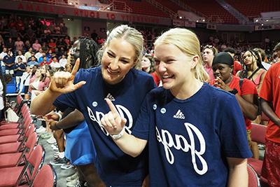 Two students smiling holding up J sign for Jaguars.